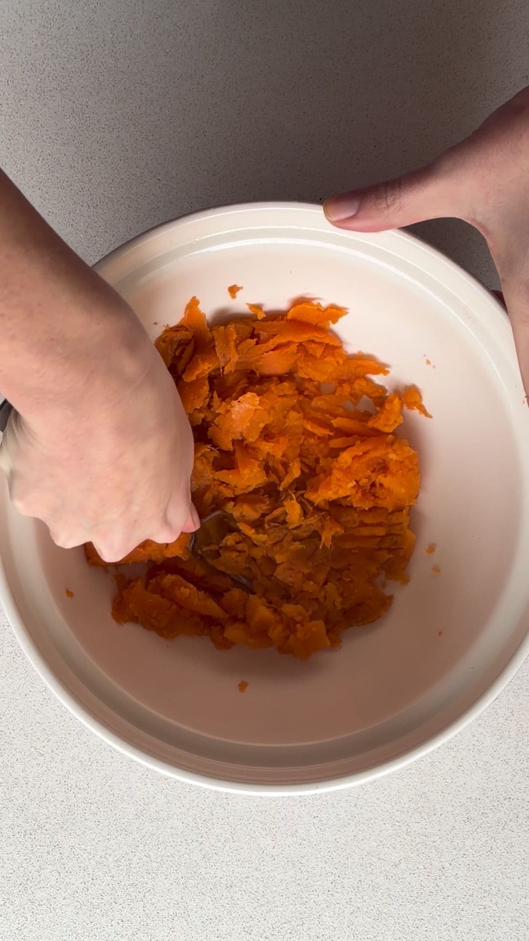 Mashing sweet potato flesh in a bowl