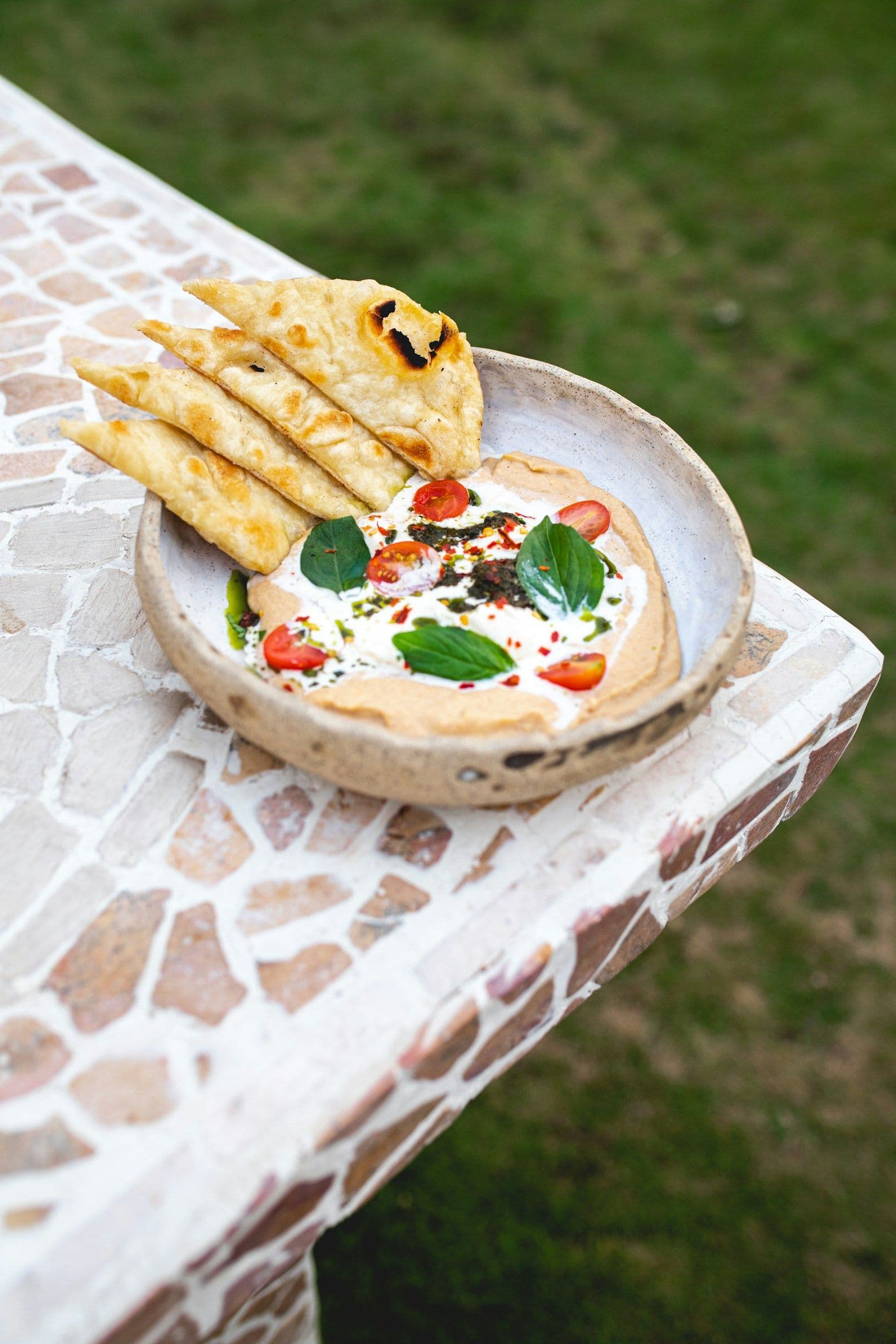Sourdough flatbread served with whipped feta dip, tomatoes and herbs
