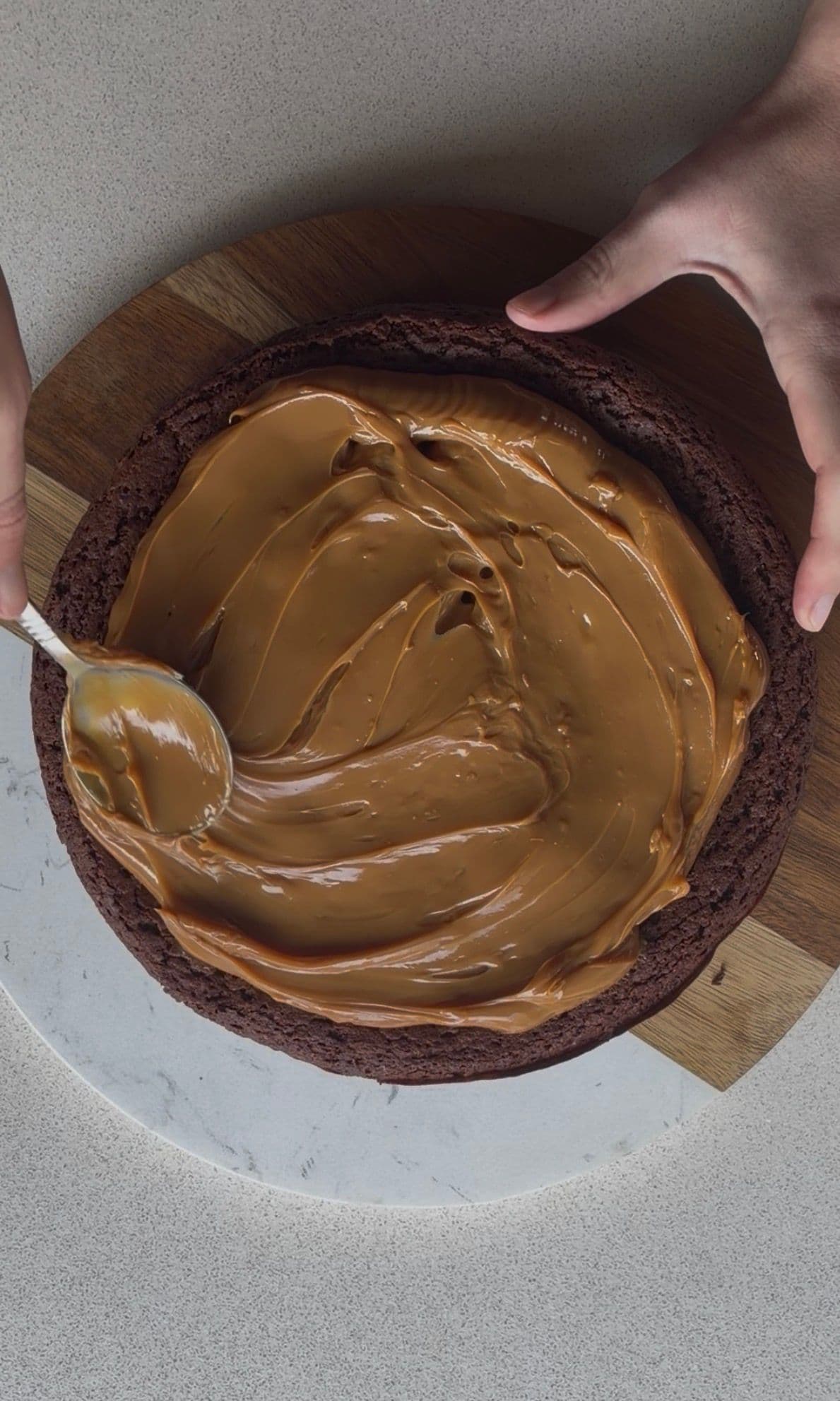 Spreading dulce de leche over the cooled base
