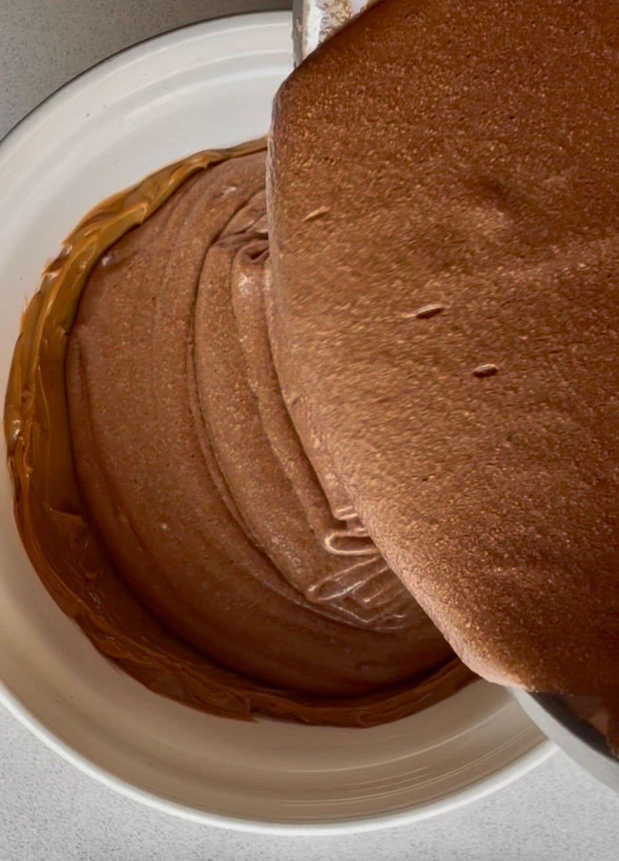 Pouring the mousse over the dulce de leche base