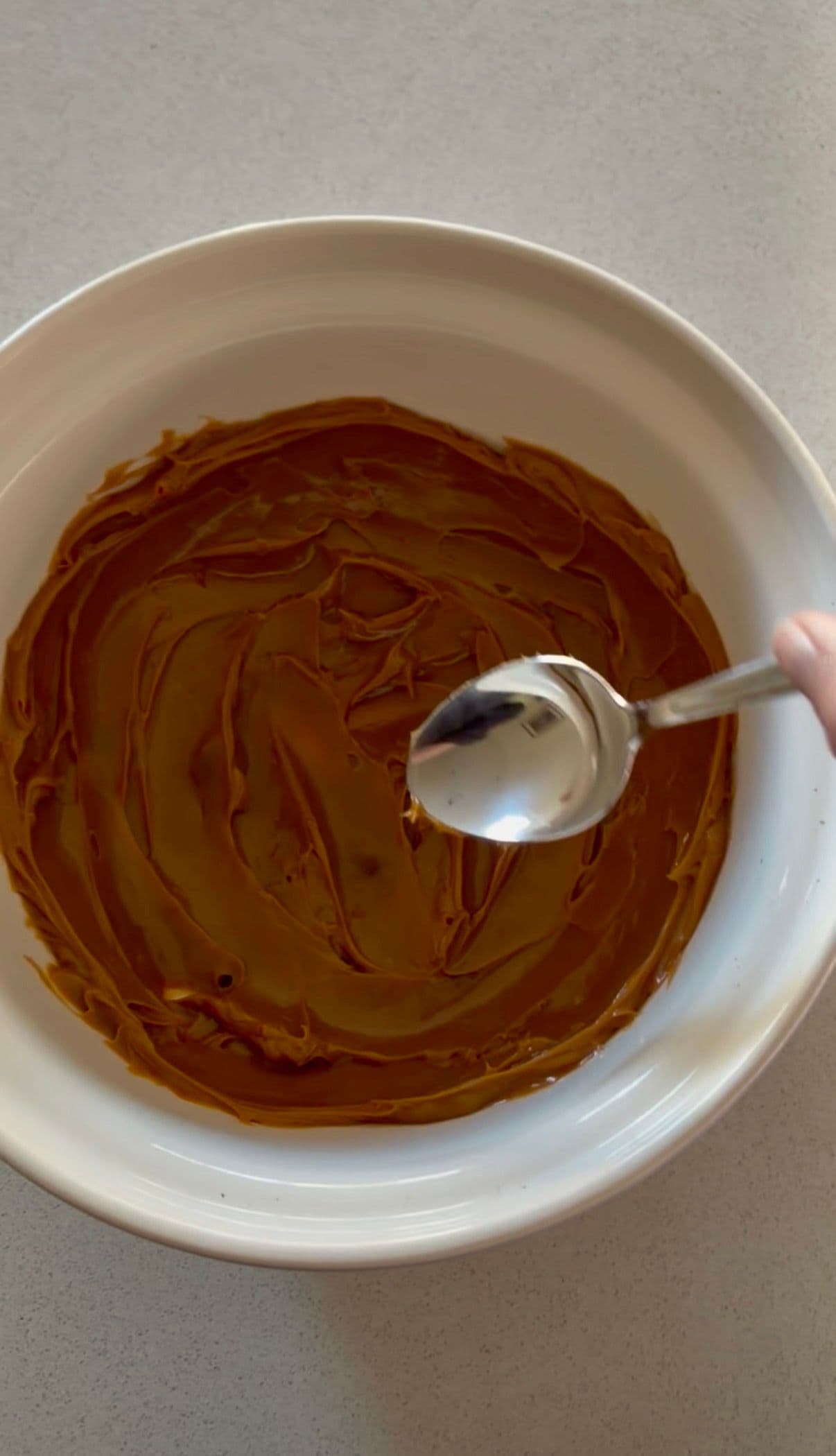Spreading dulce de leche into the bottom of the serving bowl