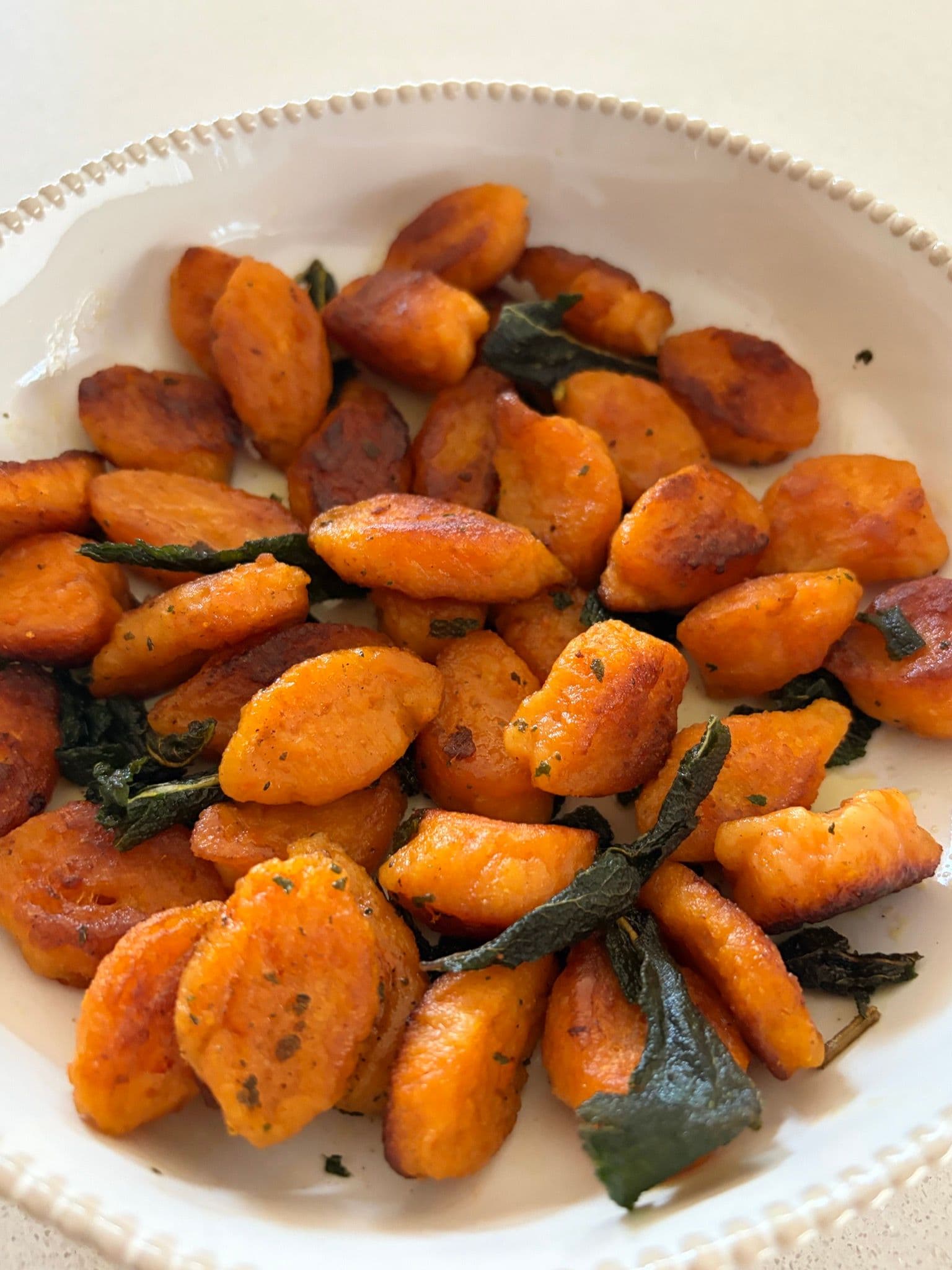 Sweet potato gnocchi with brown butter and sage on a plate