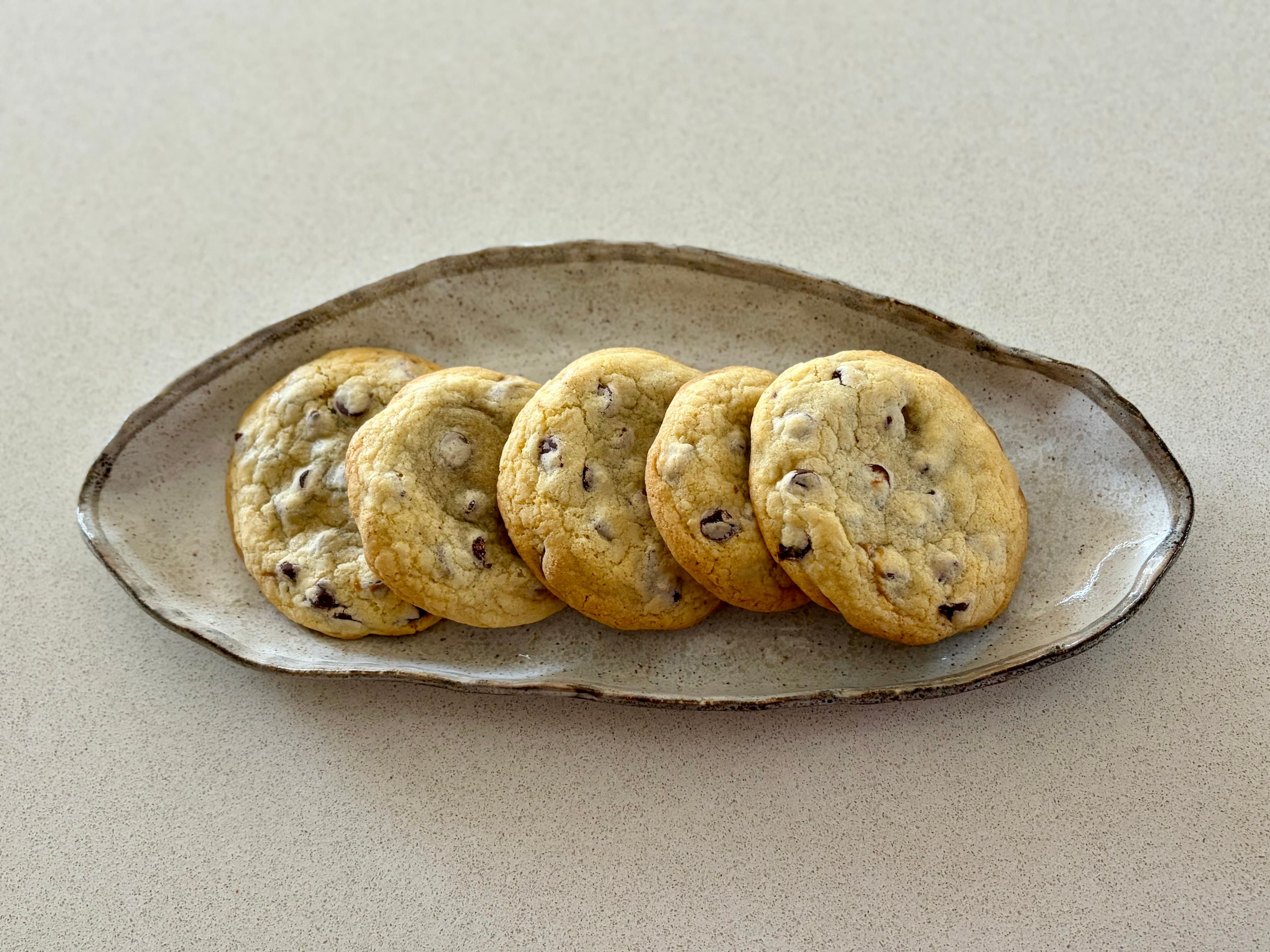 Chocolate chip cookies with dulce de leche heart, broken open to show the molten centre