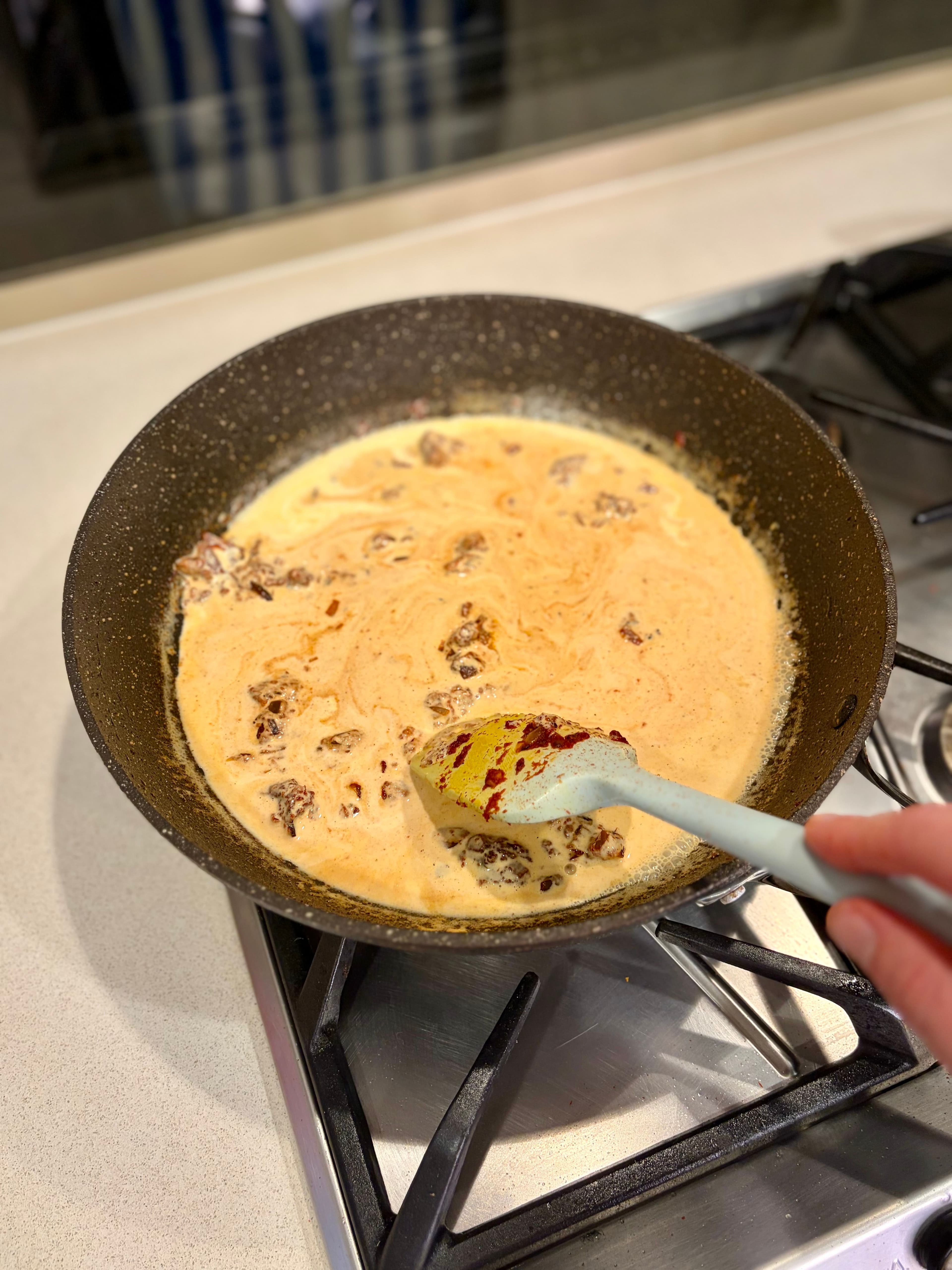 Stirring cream into tomato paste